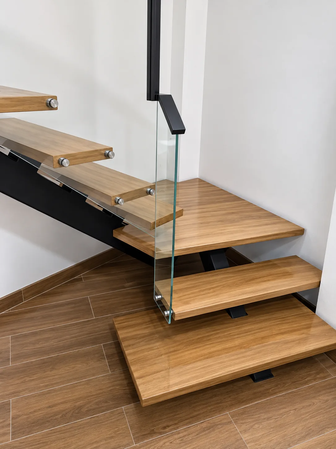 Escalera moderna con estructura metálica, madera y vidrio